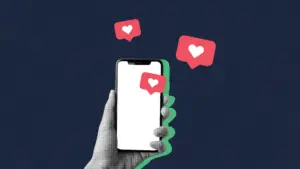 a hand holding a cell phone up with heart "likes" floating around it