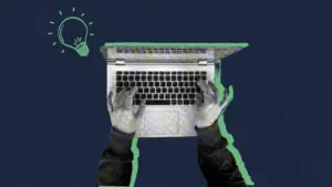 Overhead view of hands typing on a laptop with a lightbulb showing website redesign advice