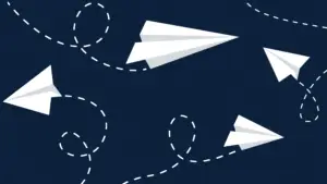 Paper airplanes flying around on dark blue background